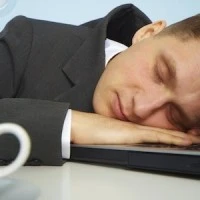 Tired man sleeping on a notebook